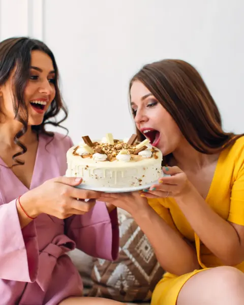 Amigas celebrando con una torta de chocolate