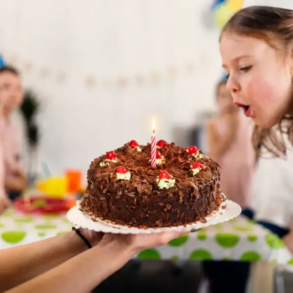 Niña soplando las velas de su torta